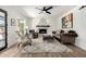 Cozy living room with decorative fireplace, ceiling fan, wood flooring, and neutral furnishings at 5211 E Winchcomb Dr, Scottsdale, AZ 85254