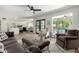 Spacious living room and dining area with wood floors, neutral furnishings, and pool views at 5211 E Winchcomb Dr, Scottsdale, AZ 85254
