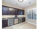 Entertainer's bar area with dual wine refrigerators, sleek counter, and ample dark wood cabinetry at 5243 E Windstone Trl, Cave Creek, AZ 85331