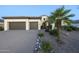 Inviting home showcasing a front yard with rock accents, mature palm trees, and a two-car garage at 5243 E Windstone Trl, Cave Creek, AZ 85331