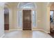 Inviting foyer with arched entryways, tile flooring, and a decorative wooden front door at 5243 E Windstone Trl, Cave Creek, AZ 85331