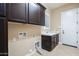 Practical laundry room with upper cabinets, countertop sink, tile flooring, and essential appliance connections at 5243 E Windstone Trl, Cave Creek, AZ 85331