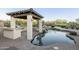 Outdoor pool area features a gazebo, built-in grill, and rock waterfall feature at 5243 E Windstone Trl, Cave Creek, AZ 85331