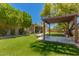 Serene backyard with pergola, lush lawn, and manicured landscaping at 5312 S Hazelton Ln, Tempe, AZ 85283