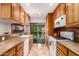 Galley kitchen features tile floors, wood cabinets, tile backsplash, and access to the backyard at 5312 S Hazelton Ln, Tempe, AZ 85283