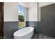 The bathroom offers a soaking tub with a large window overlooking the outdoor landscaping at 5540 E Mercer Ln, Scottsdale, AZ 85254