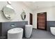 This modern bathroom has stylish fixtures, and pedestal sinks and unique mirrors at 5540 E Mercer Ln, Scottsdale, AZ 85254