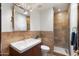 Well-lit bathroom with a granite vanity, framed mirror, decorative sconces and tiled shower with glass door at 5540 E Mercer Ln, Scottsdale, AZ 85254