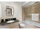 Bright bathroom featuring a glass-enclosed tub, granite countertop, and neutral tile at 5540 E Mercer Ln, Scottsdale, AZ 85254