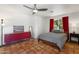 Bedroom boasts terracotta floors, ceiling fan, red mid-century dresser and neutral decor at 5540 E Mercer Ln, Scottsdale, AZ 85254