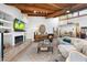 Spacious living room with beamed ceilings, fireplace, stylish furniture, and ample natural light at 5540 E Mercer Ln, Scottsdale, AZ 85254