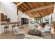 Bright living room features a wood beam ceiling, bar, fireplace, and inviting seating arrangement at 5540 E Mercer Ln, Scottsdale, AZ 85254