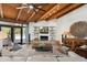 Modern living room with beamed ceilings, fireplace, stylish furniture, and access to the patio at 5540 E Mercer Ln, Scottsdale, AZ 85254