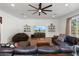 Cozy living room features a large sectional sofa, ceiling fan and television at 5540 E Mercer Ln, Scottsdale, AZ 85254