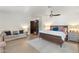 Light filled main bedroom features a sitting area, ceiling fan, and access to a private bathroom at 5540 E Mercer Ln, Scottsdale, AZ 85254