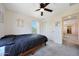 Well-lit bedroom features a ceiling fan, window, and closet space with a calming, neutral color palette at 5805 W Warner St, Phoenix, AZ 85043