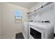 Bright laundry room with a front-load washer and dryer, storage shelves and a window for natural light at 5805 W Warner St, Phoenix, AZ 85043