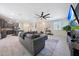 Open concept living space with a plush sectional sofa, sleek tile flooring, and a modern kitchen at 5805 W Warner St, Phoenix, AZ 85043