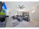 Spacious living room featuring a plush sectional sofa, ceiling fan, tile flooring and modern decor at 5805 W Warner St, Phoenix, AZ 85043