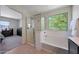 Bright main bathroom featuring a walk-in shower, soaking tub, and neutral tile floors at 5805 W Warner St, Phoenix, AZ 85043