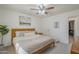 Bright bedroom featuring a ceiling fan, neutral decor, a comfy bed, and a glimpse into an adjacent space at 643 N 92Nd Pl, Mesa, AZ 85207