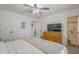 Well-lit bedroom with an open doorway to the bathroom and views of the dresser and mounted television at 643 N 92Nd Pl, Mesa, AZ 85207