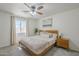 Cozy bedroom with a ceiling fan, neutral walls, a comfortable bed, and natural light from the window at 643 N 92Nd Pl, Mesa, AZ 85207