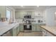Modern kitchen features stainless steel appliances, green cabinets, white subway tile backsplash, and a farmhouse sink at 643 N 92Nd Pl, Mesa, AZ 85207