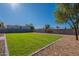 A well-maintained backyard with green grass, block fencing, and desert landscaping at 656 E Mesquite Ave, Apache Junction, AZ 85119