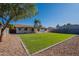 A spacious backyard featuring a lush lawn, rock landscaping, and a charming covered patio, perfect for outdoor gatherings at 656 E Mesquite Ave, Apache Junction, AZ 85119