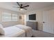 Well-lit bedroom featuring a ceiling fan, a large window, and a modern dresser with a mounted TV at 656 E Mesquite Ave, Apache Junction, AZ 85119