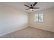 Minimalist bedroom with neutral tones, a ceiling fan, and a view of the outdoor landscape at 656 E Mesquite Ave, Apache Junction, AZ 85119