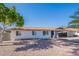 Well-maintained single-story home featuring desert landscaping, a covered carport, and a clear blue sky at 656 E Mesquite Ave, Apache Junction, AZ 85119