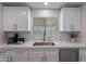 Well-lit kitchen with stainless steel appliances, white cabinets, light countertops, and modern fixtures at 656 E Mesquite Ave, Apache Junction, AZ 85119