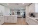 Open-concept kitchen seamlessly flowing into the living area, featuring modern appliances, light countertops, and white cabinetry at 656 E Mesquite Ave, Apache Junction, AZ 85119