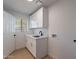 Well-lit laundry room with white cabinets, modern sink, and stylish flooring at 656 E Mesquite Ave, Apache Junction, AZ 85119