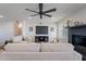 Comfortable living room featuring a modern ceiling fan, TV, and a painted brick fireplace at 656 E Mesquite Ave, Apache Junction, AZ 85119