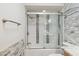 Bathtub and shower combo with glass doors and decorative tile at 7036 E Sheena Dr, Scottsdale, AZ 85254