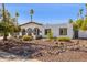 Charming home features a rock garden and lovely desert landscaping at 7036 E Sheena Dr, Scottsdale, AZ 85254