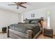 Main bedroom with a ceiling fan, wood floors, and a comfortable king-sized bed at 7036 E Sheena Dr, Scottsdale, AZ 85254