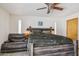 Main bedroom with a ceiling fan, wood floors, couch and a comfortable king-sized bed at 7036 E Sheena Dr, Scottsdale, AZ 85254