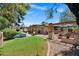 Large backyard with lush green grass, mature trees, sparkling pool, and outdoor kitchen perfect for entertaining guests at 7202 N 16Th Dr, Phoenix, AZ 85021