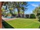 Spacious backyard features lush green grass, mature trees, and a sparkling pool, perfect for outdoor enjoyment at 7202 N 16Th Dr, Phoenix, AZ 85021