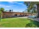 Expansive backyard showcasing a covered patio, pristine lawn, and sparkling pool, ideal for relaxation and entertainment at 7202 N 16Th Dr, Phoenix, AZ 85021