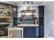 Contemporary bar area featuring blue cabinetry, wine storage, stylish decor, and a functional countertop for entertaining at 7202 N 16Th Dr, Phoenix, AZ 85021