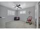This cozy bedroom boasts two shuttered windows, a ceiling fan and a rocking chair at 7202 N 16Th Dr, Phoenix, AZ 85021