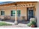 Cozy covered front porch with seating area, decorative plants, and a secure screen door at 7202 N 16Th Dr, Phoenix, AZ 85021
