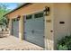 Close-up view of a two-car garage with stylish blue doors and classic exterior lighting at 7202 N 16Th Dr, Phoenix, AZ 85021