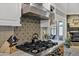 Kitchen with custom tile backsplash, stainless steel hood, and gas cooktop at 7202 N 16Th Dr, Phoenix, AZ 85021