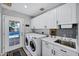 Laundry room with sink, washer, dryer, door to the back yard, and white cabinets at 7202 N 16Th Dr, Phoenix, AZ 85021